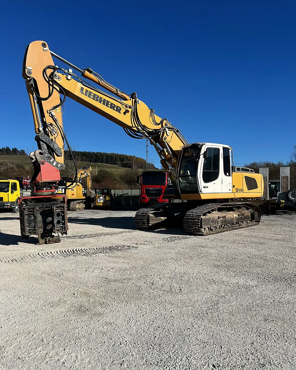 Liebherr excavator with a MOVAX vibratory pile driver driving sheet piles on a gravel plateau
