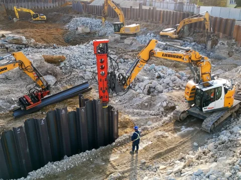 Rýpadlá Liebherr pri zatĺkaní štetovníc vibračným kladivom do steny stavebnej jamy