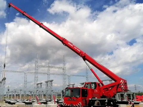 Červený autožeriav Liebherr LTM 1040 s vysunutým ramenom pri montáži v areáli rozvodne